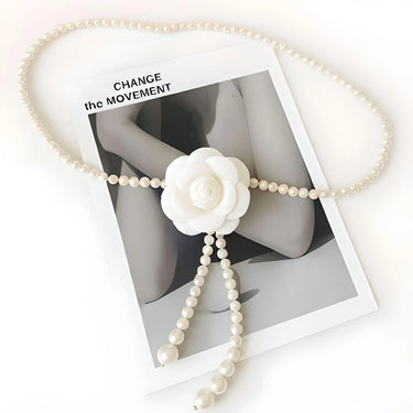 Pearl waist belt with a white flower pendant on a magazine cover